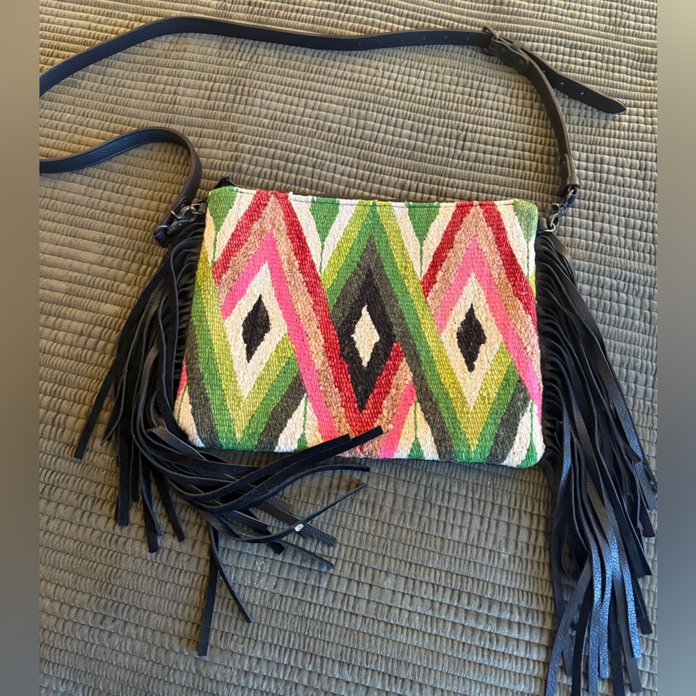 Totem multi colored kilm like and black leather crossbody bag with fringe.